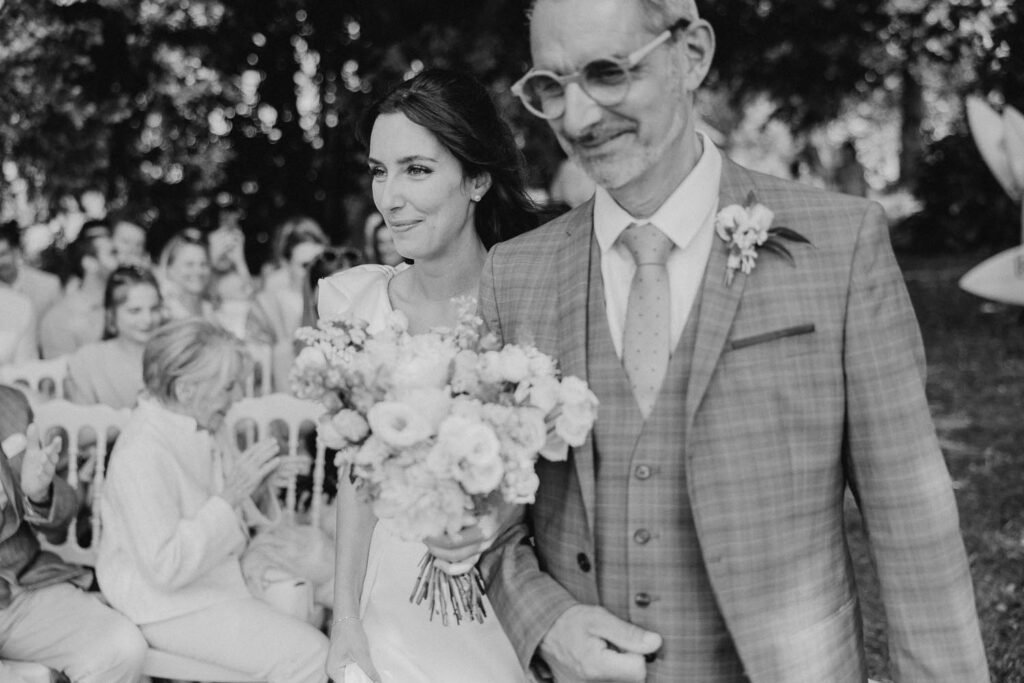entrée des mariés lors de leur cérémonie dans les jardins du château biscay