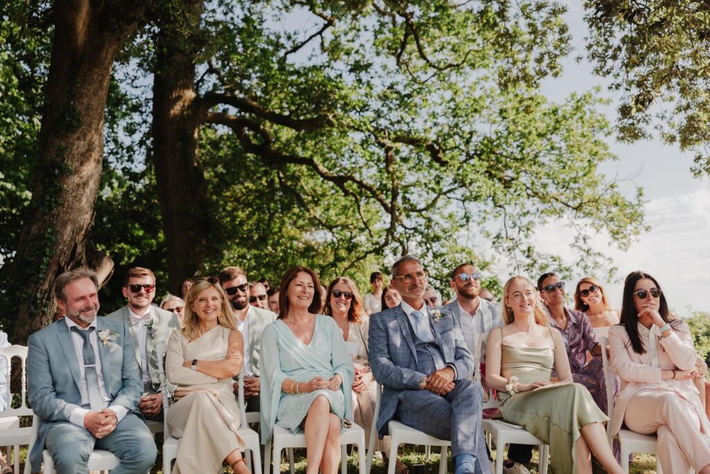 invités qui sourient pendant une cérémonie de mariage au chateau de biscay