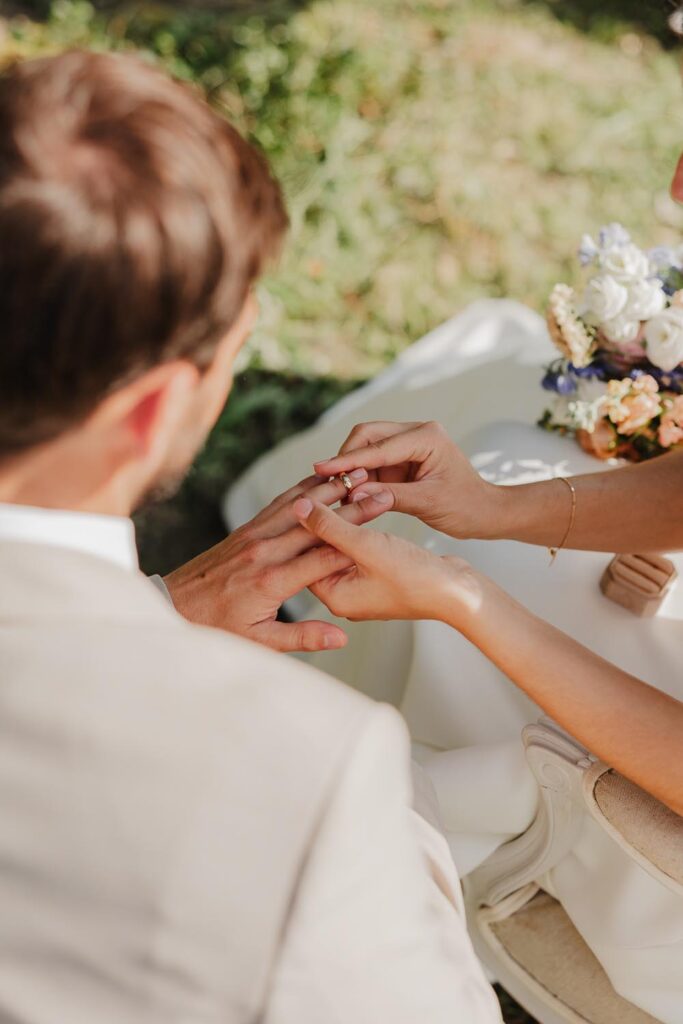 mariée qui passe la bague au doigt du marié pendant leur cérémonie de mariage au pays basque