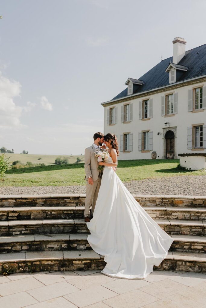 seance photo des mariés dans les marches d'escalier devant le chateau de biscay