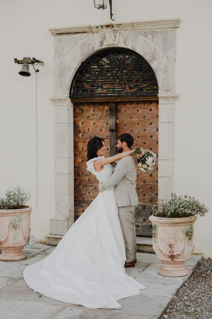seance photo des mariés devant la porte d'escalier devant le chateau de biscay