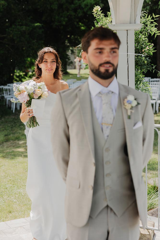 marié de dos qui attend la mariée sous la rotonde du chateau