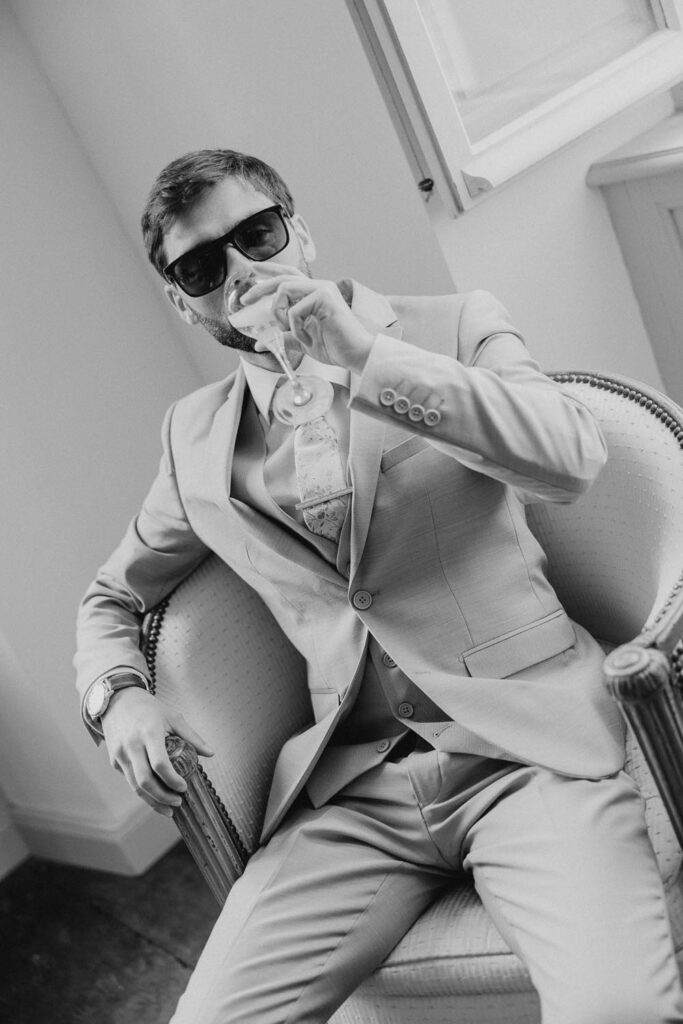 le marié boit une coupe de champagne lors de son mariage au château de biscay