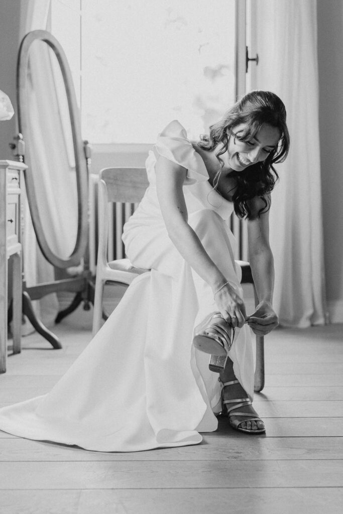 mariée qui enfile ses chaussures pendant ses préparatifs au château de biscay