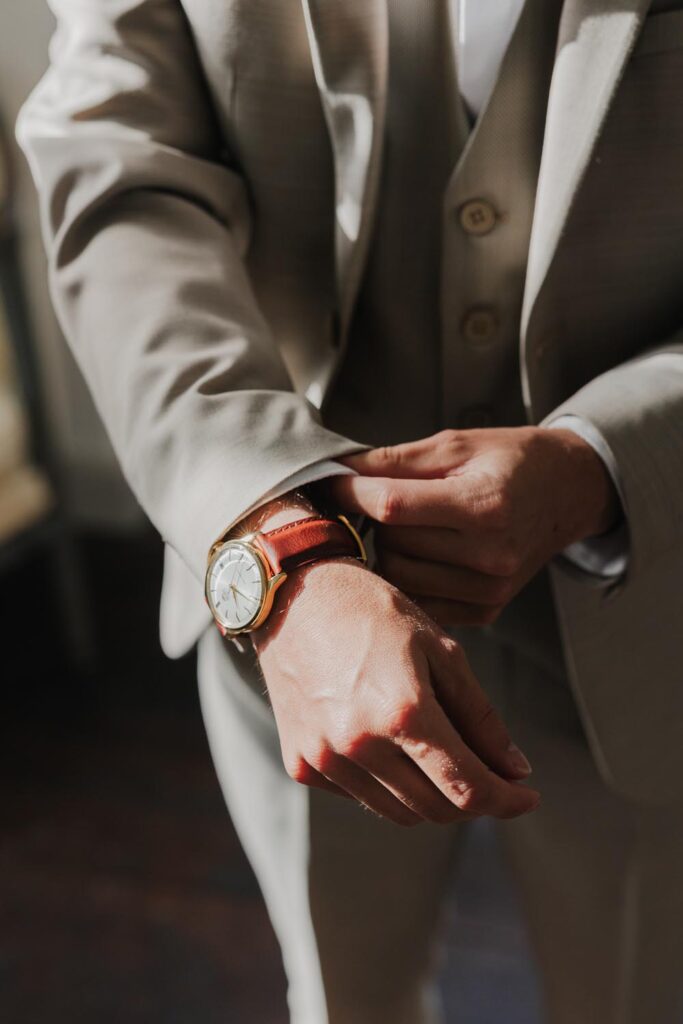 marié qui enfile sa montre pendant ses préparatifs au château de biscay