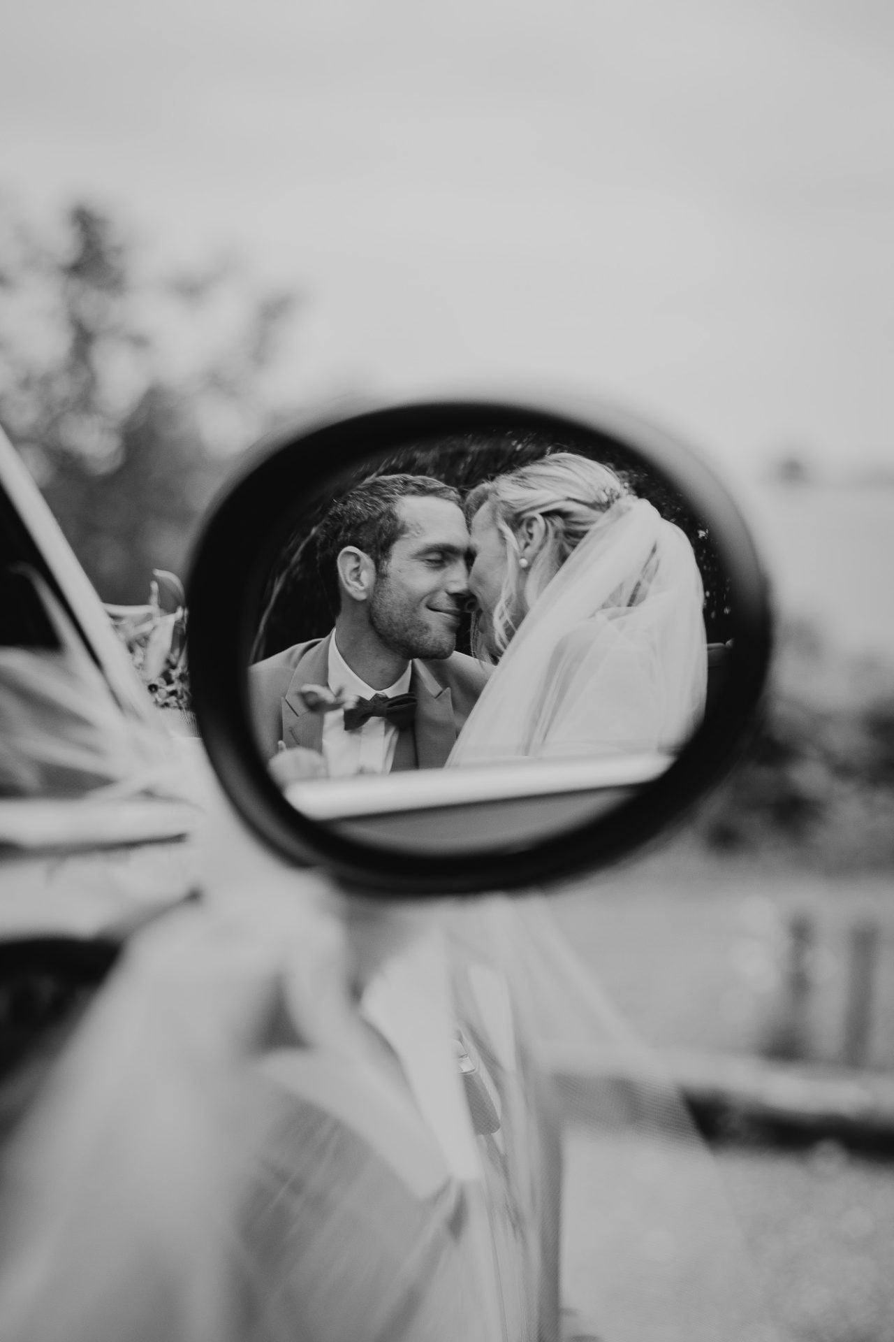 portait romantique de mariés amoureux dans un rétroviseur de voiture