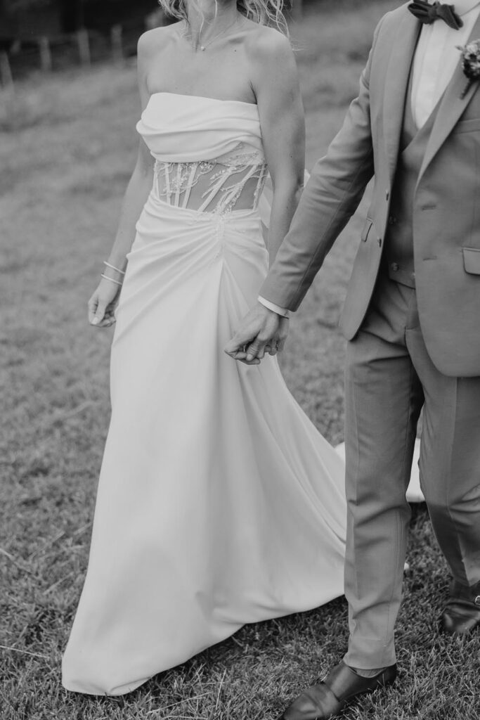 mariés qui se tiennt la main lors d'une séance photo couple lors d'un mariage à bardos au domaine etxezahar