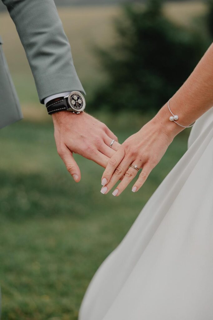 alliances et mains des mariés pendant une séance photo couple lors d'un mariage à bardos au domaine etxezahar
