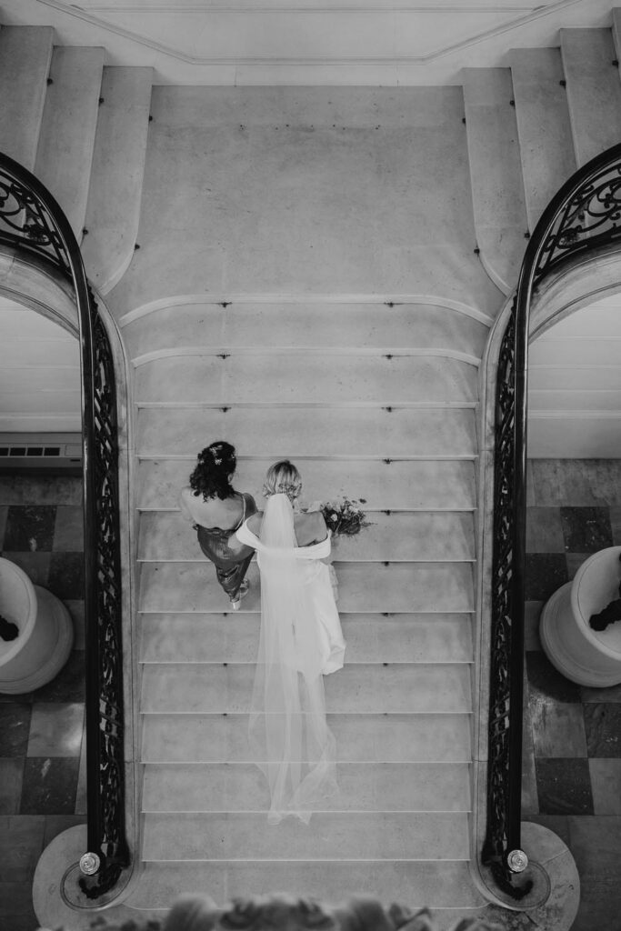 mariée qui monte les marches de la mairie de bayonne lors de son mariage au pays-basque